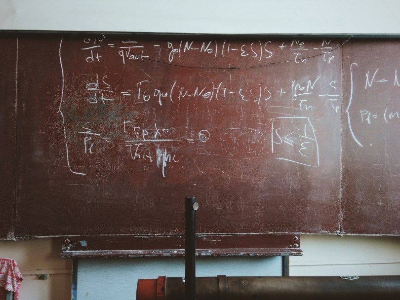 chalkboard with complex mathematical equations and solutions