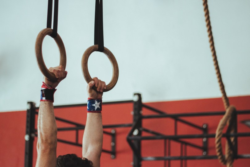 gymnast practicing routine on the rings