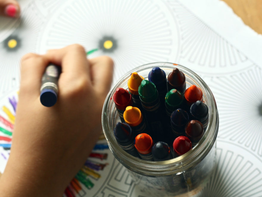 child coloring with crayons