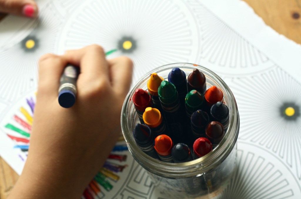 child coloring with crayons