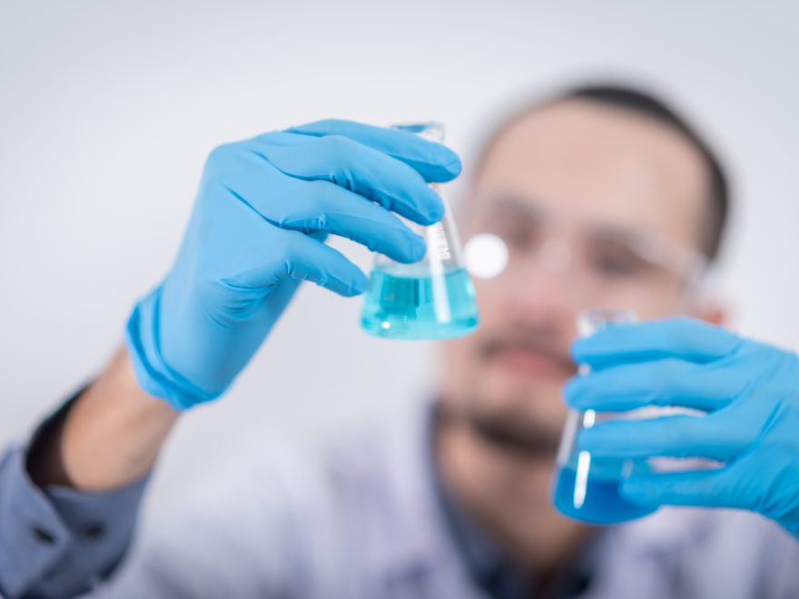 scientist with chemicals in flasks